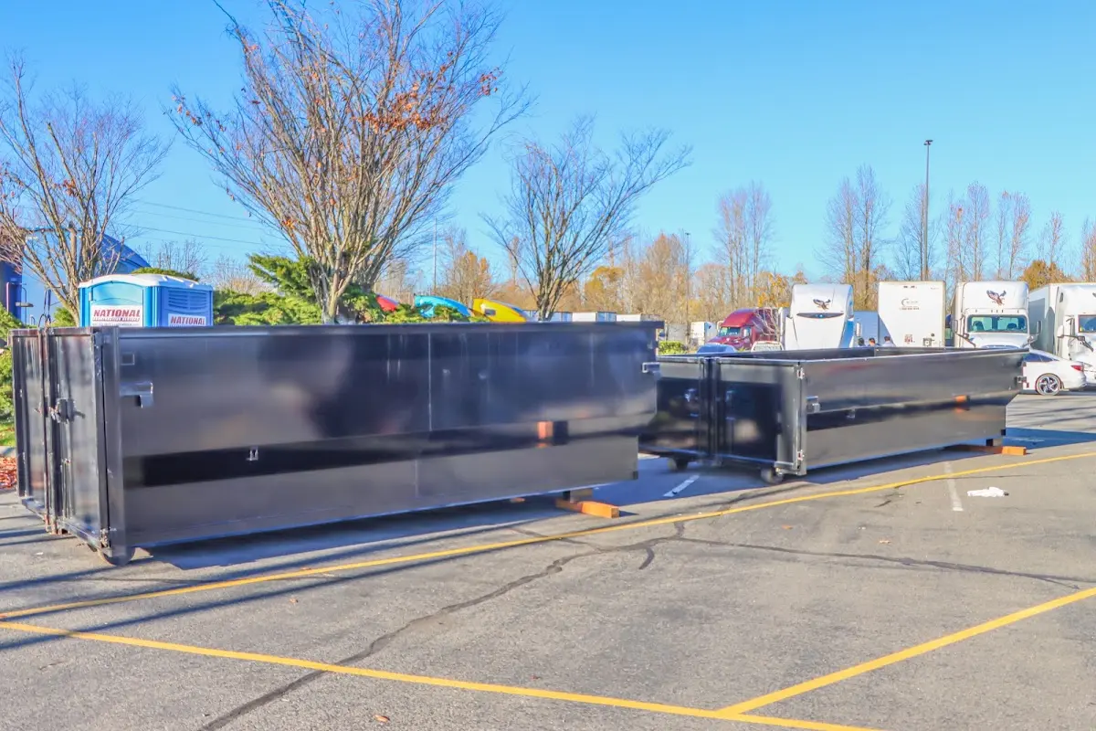 Professional dumpster rental service with roll-off container on residential driveway in Box Elder